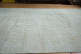 Distressed Oushak carpet with muted neutral tones and textured pile.