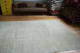 Distressed Turkish Oushak carpet with subtle faded medallions and soft neutral tones.
