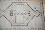 Decorative charcoal geometric medallion detail on this ivory distressed Oushak runner.