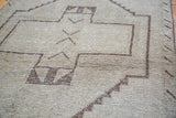 Distressed charcoal and ivory geometric pattern on a vintage Oushak runner pile.