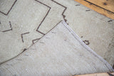 Distressed Oushak rug runner's hand-knotted foundation and geometric ivory pile.