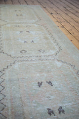 Distressed vintage Oushak runner's textured pile, blanched tones and abstract patterns.