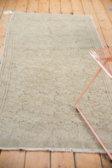 Vintage Turkish Oushak's blanched, distressed texture with faded scrolling vines.