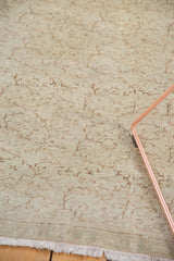 Blanched distressed pile and scrolling vine pattern on a vintage Turkish Oushak rug.