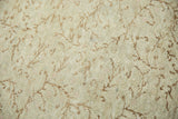 Distressed blanched Oushak rug pile with airy scrolling light brown vine patterns.