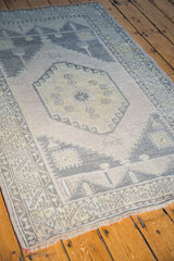 Soft apricot mauve field and faded geometric patterns of the distressed Oushak rug.