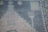 Vintage Turkish Oushak rug's textured geometric pattern in charcoal, apricot mauve, and gold.