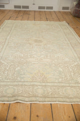 Faded ivory and brown sprawling medallion design on a distressed vintage Oushak rug.