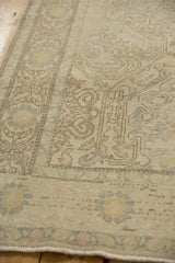 Distressed Turkish Oushak rug detail, showing faded ivory and brown shadow outline patterns.
