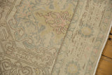 Distressed Oushak rug texture reveals faded pink, blue, ivory tones and soft fringe.