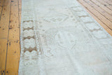 Distressed Oushak runner with faded geometric motifs and worn tone-on-tone texture.
