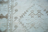 Distressed Oushak runner with worn texture, light beige pile, and subtle brown geometric motifs.