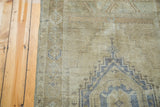 Vintage Distressed Oushak rug showing geometric medallion in faded silver and bronze.