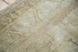 Distressed Oushak rug's textured pile, revealing muted gold and soft bronze patterns.
