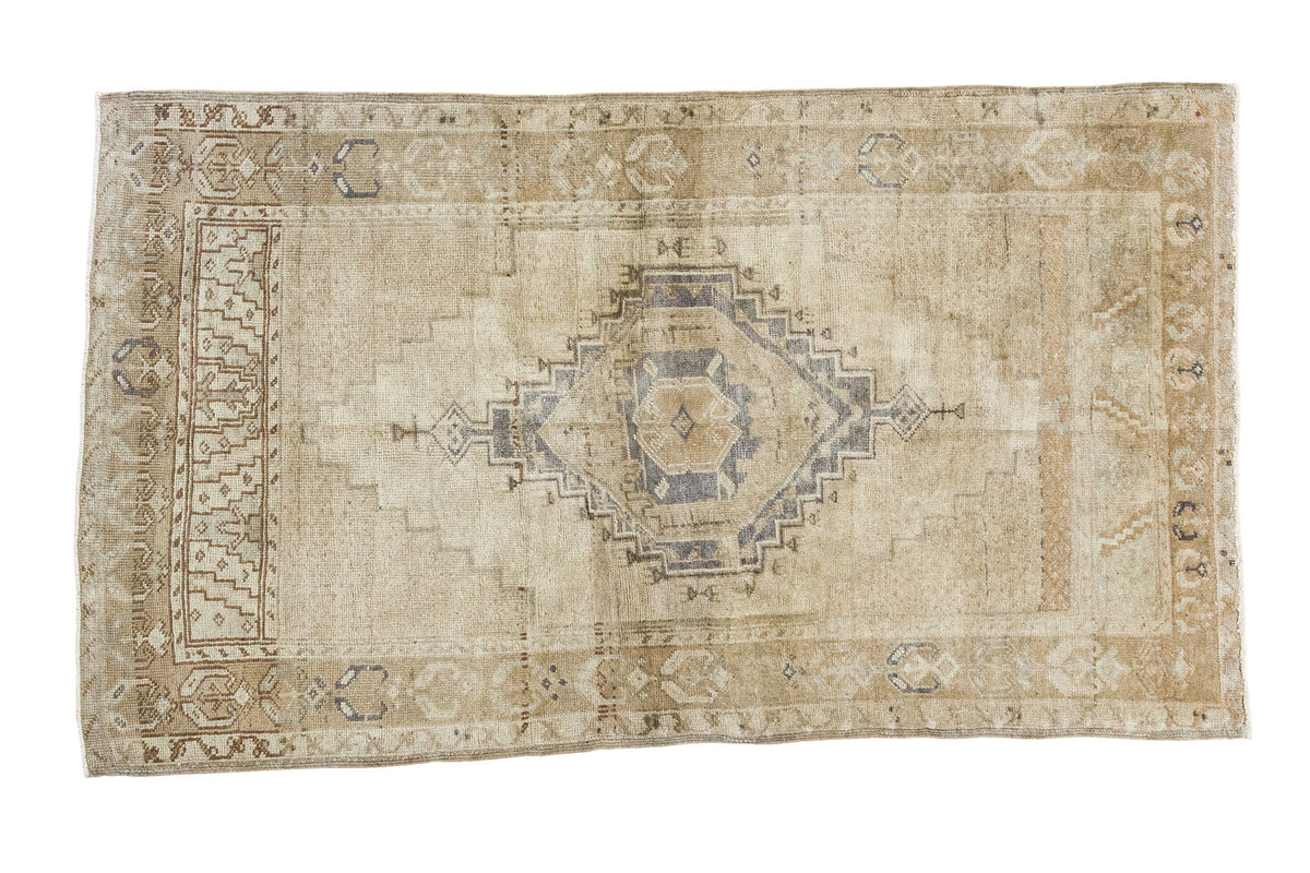 Distressed vintage Turkish Oushak rug with silver medallion, meandering border, soft beige and gold.
