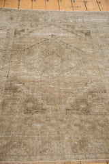 Soft sandy earth tones and low, worn pile texture of the distressed Oushak rug.