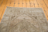 Distressed vintage Oushak rug edge, highlighting soft sandy earth tones and worn pile.