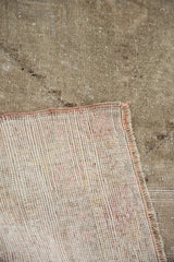 Hand-knotted foundation of the vintage Oushak rug, showing its distressed sandy pile and woven edge.