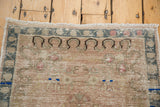 Distressed Oushak rug corner with fringe, blanched pastel border, and faded motifs.