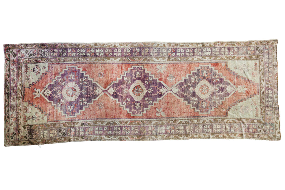 Distressed Oushak runner, sun-softened violet and grapefruit red geometric medallions, 4'4" x 11'9".