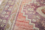 Distressed Oushak runner's thin pile, revealing sun-softened violet and grapefruit red geometric abrash.