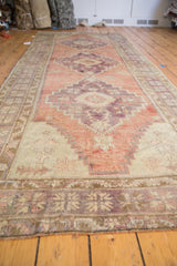 Close-up of distressed Oushak runner's original selvage with violet and bronze border.