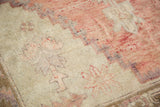 Thin, distressed pile of Oushak runner, with faded grapefruit red and violet geometric steps.