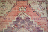 Distressed Oushak runner showing stepped geometric pattern in violet and grapefruit red with abrashes.