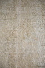 Faded Oushak rug's distressed texture showing blanched ivory and light grey tones.