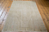 Distressed texture and blanched ivory, grey tones of the vintage Oushak rug.