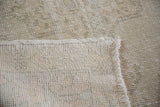 Hand-knotted foundation, fringed edge, and blanched pile of the distressed Oushak rug.