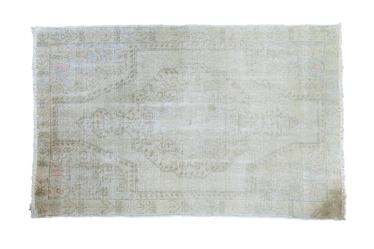 Distressed vintage Oushak rug with large faded medallion, blanched ivory, grey, soft rose, 4'2" x 6'7".