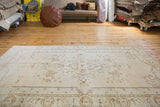 Distressed Oushak rug with faded ornate medallion and field patterns in soft saffron gold.