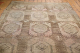 Distressed Oushak rug texture with geometric medallions and soft rose earth tones.