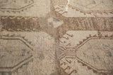 Distressed Oushak rug's hand-knotted pile with worn geometric motifs and soft earth tones.