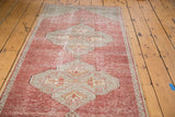 Distressed cinnabar red field with an oversized geometric medallion and slate grey motifs.