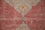 Geometric medallion detail of distressed Oushak runner with ivory and gold motifs on slate grey and cinnabar red.