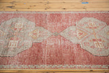 Distressed Oushak runner with geometric grey medallion on cinnabar red field.