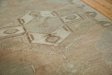 Close-up of distressed Oushak runner showing geometric tree motifs in soft earth tones.