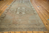 Distressed Oushak runner's fringed end, highlighting soft beige, grey, and rose textured pile.