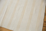 Repurposed vintage dhurrie weave textile with bleached ivory and golden beige stripes.