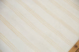 Bleached ivory cotton dhurrie flatweave showcasing finely woven golden beige stripes.