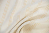 Bleached ivory cotton flatweave rug showing subtle beige and gold striped texture.