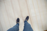 Finely woven texture of the vintage flatwoven dhurrie carpet with bleached ivory and subtle stripes.