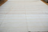Textured cotton dhurrie flatweave with subtle bleached ivory and pale beige stripes.