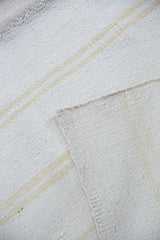 Vintage dhurrie weave in bleached ivory cotton, featuring beige stripes and a visible seam.