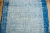 Distressed Oushak runner showing light blue pile texture and narrow dark blue border.