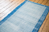 Distressed Oushak runner with a vibrant blue narrow border and low pile texture.
