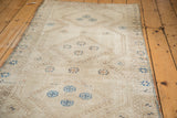 Geometric pattern in tone-on-tone beige and sand with blue and brown motifs.