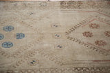 Hand-knotted texture and geometric patterns in beige, sand, and soft blue tones.